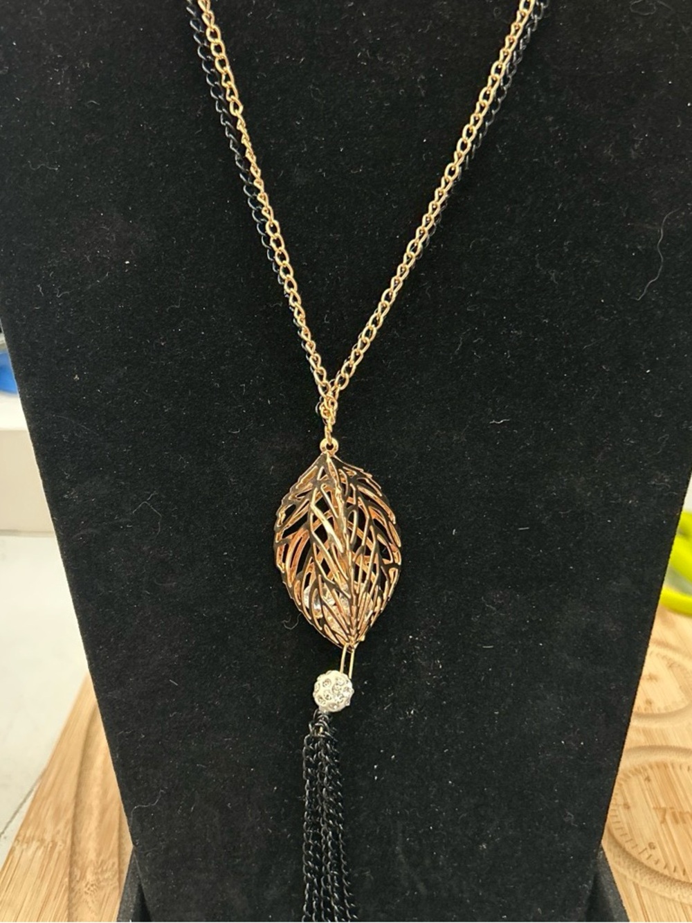 Gold color necklace with leaf pendant and tassel